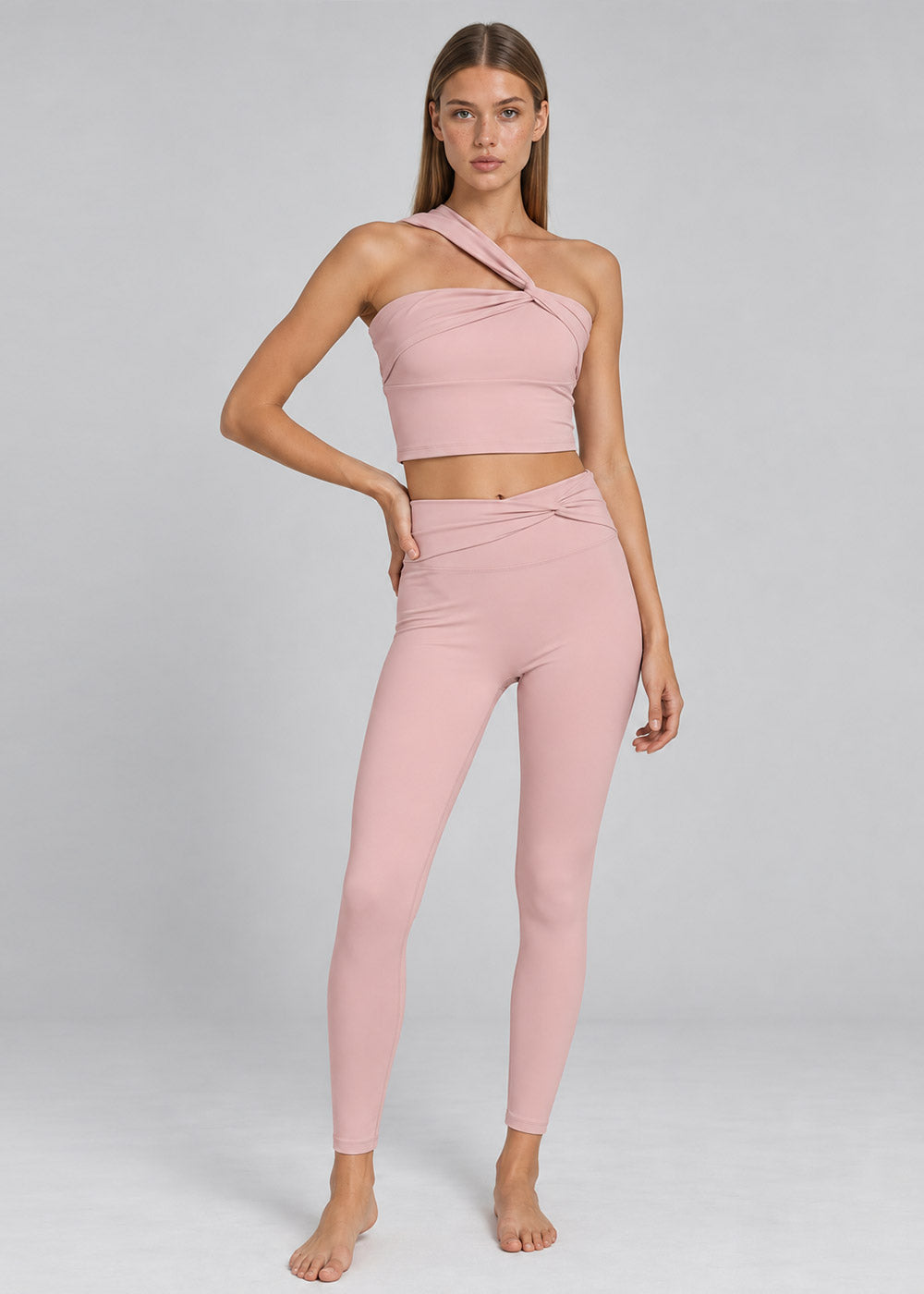 Blush pink one-shoulder crop top with crossover waist high-waisted leggings activewear set, front view