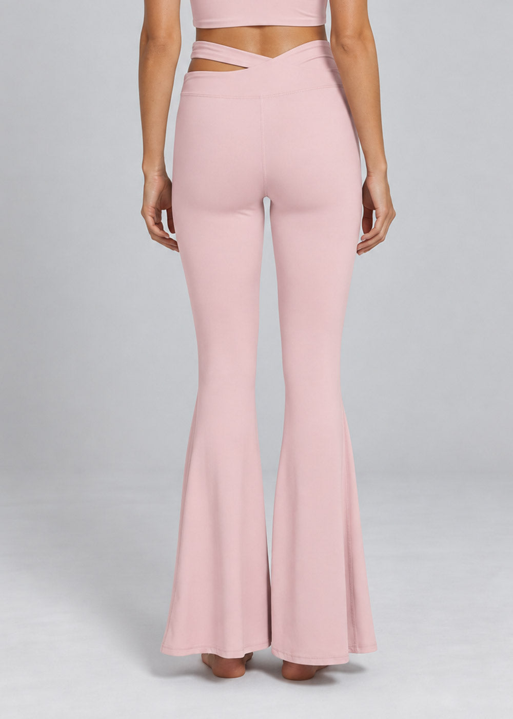 Back detail of blush pink crossover-waist flare leggings with a fitted silhouette