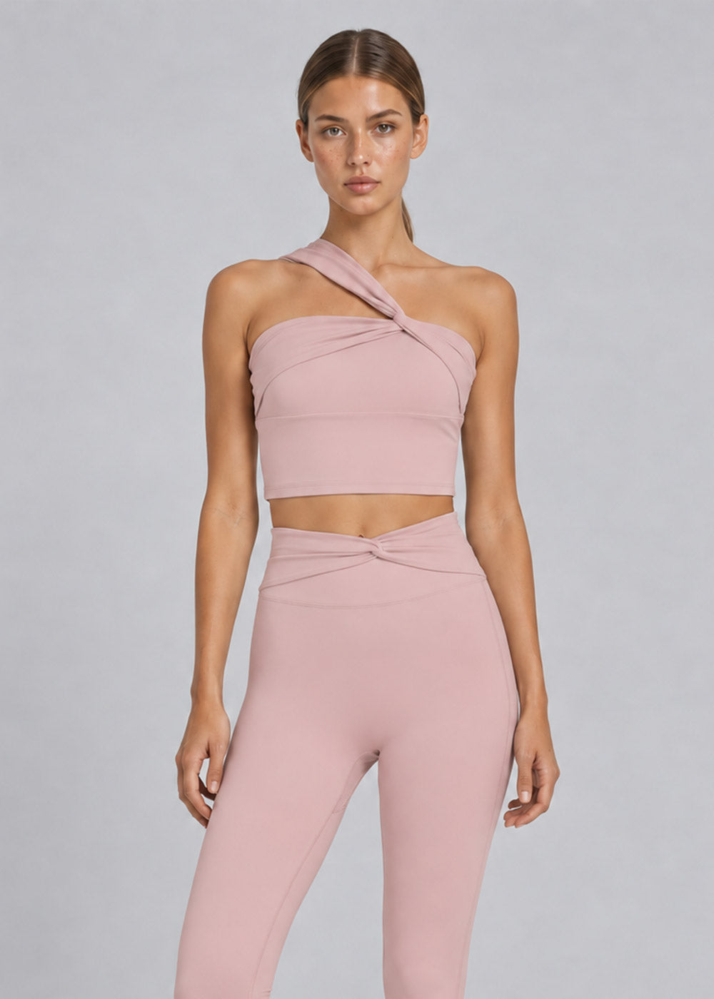 Blush pink one-shoulder crop top with crossover waist high-waisted leggings activewear set, front detail view