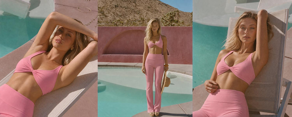 Woman wearing a pink twist-front sports bra and high-waisted flare leggings by Flowglowear in a retro poolside setting