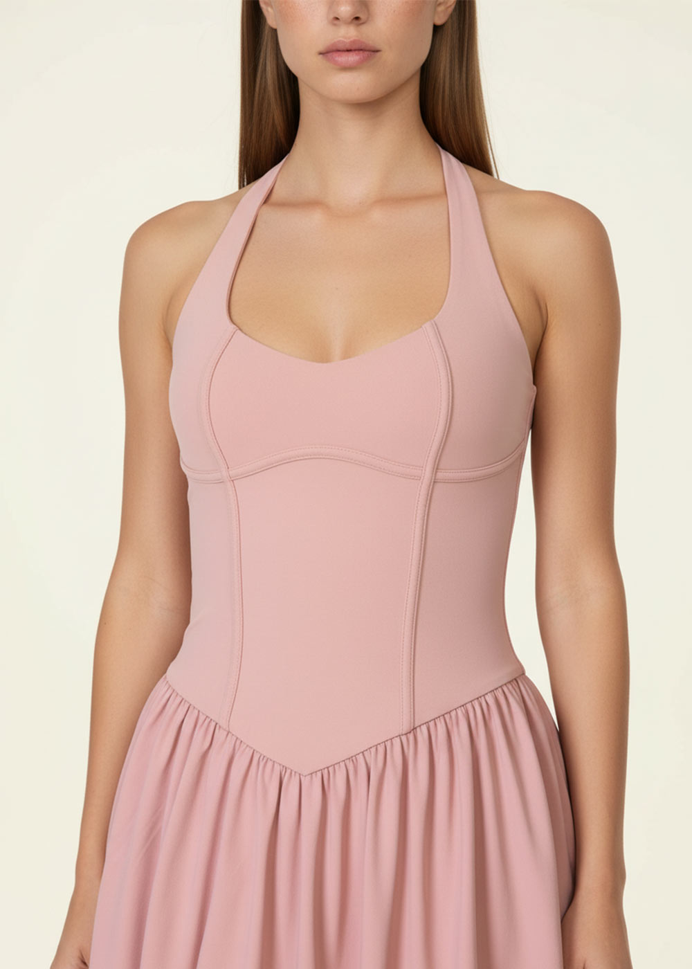 Close-up front view of a blush pink halter athletic mini dress featuring a sculpted seamed bodice and softly gathered skirt