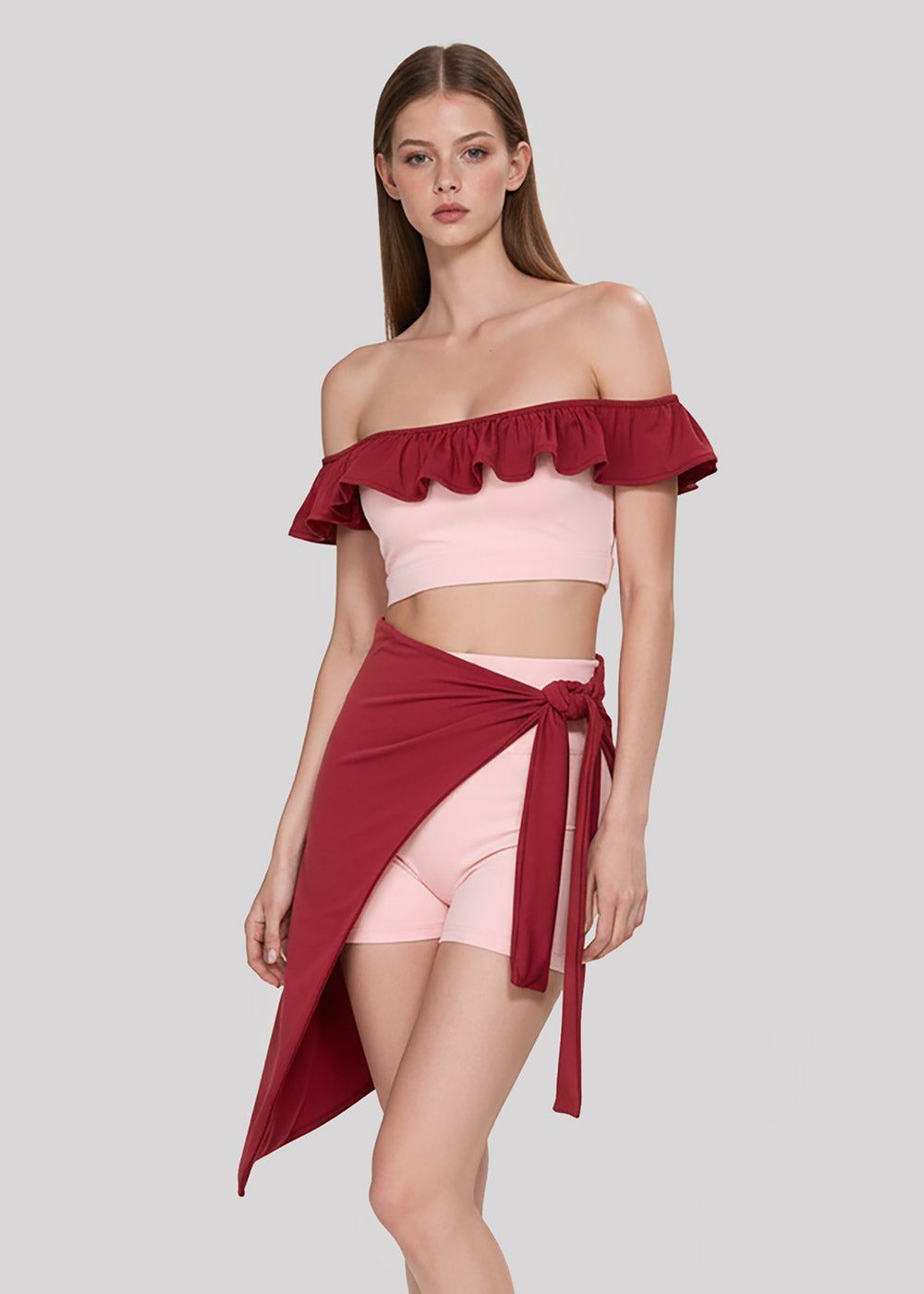 Women's blush pink off-shoulder ruffle crop top with burgundy asymmetrical wrap skirt and fitted shorts